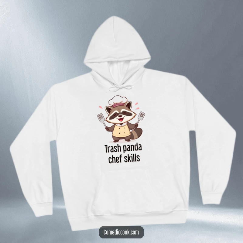 Funny raccoon chef hoodie featuring him juggling spatulas with a mischievous grin, perfect for staying warm while embracing kitchen fun.