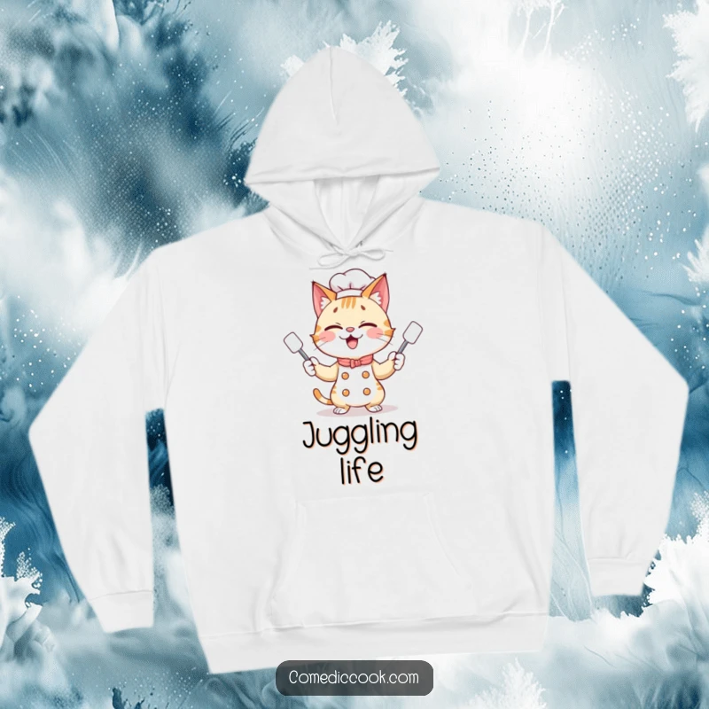 Funny giggling cat chef juggling three tiny spatulas with a playful grin, depicted on a soft and warm hoodie for ultimate comfort.